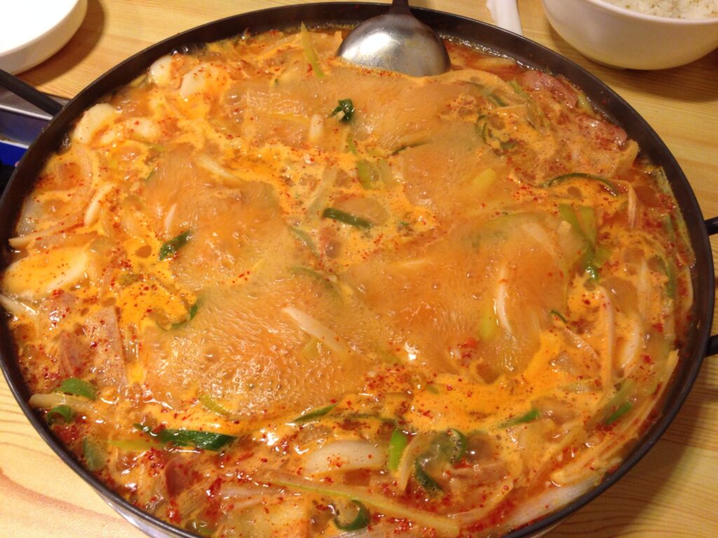 Budae-jjigae simmering with Spam, sausage, kimchi and ramen. (Wikimedia Commons)