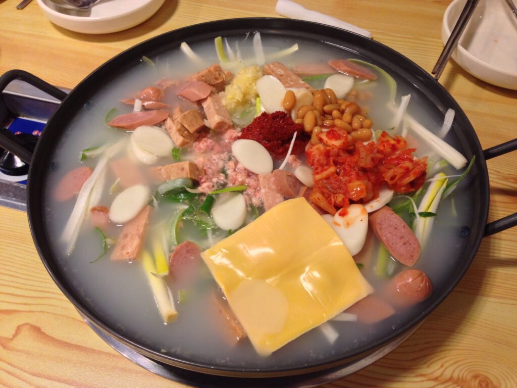 Budae-jjigae assembled in the pot before it cooks down. (Wikimedia Commons)