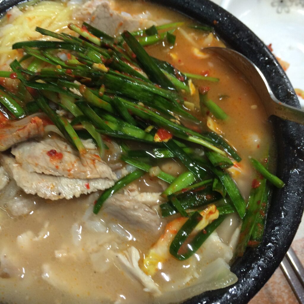 Dwaeji-gukbap with a side of seasoned garlic chives. (Wikimedia Commons)