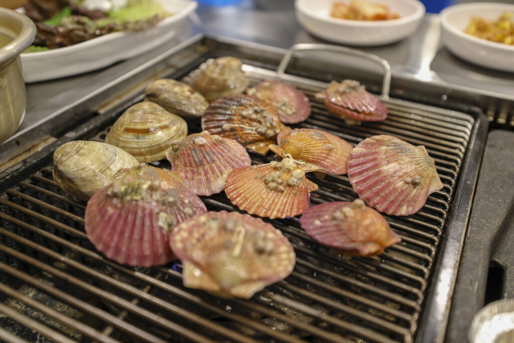 Clams and scallops cooked over charcoal. (Wikimedia Commons)