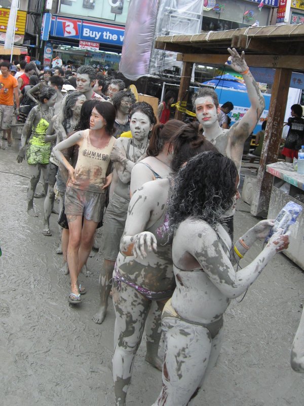 Festival-goers covered head to toe in mud. (Wikimedia Commons)