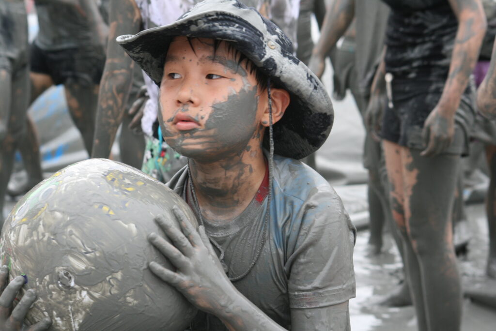 Crowds in the mud at Boryeong β peak summer, peak mess. (Wikimedia Commons)