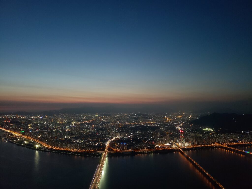 Seoul's night skyline over the Han River at dusk (illustrative; not a confirmed filming location). (Photo: Takipoint123, CC BY-SA 4.0 via Wikimedia Commons)