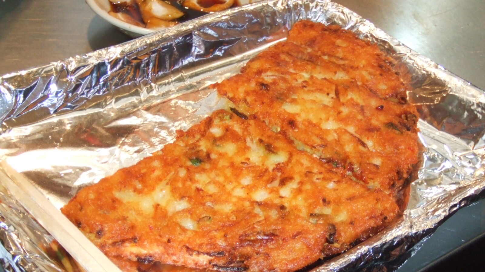 Bindaetteok (빈대떡), the crispy Korean mung-bean pancake, fresh from a street market in Seoul.