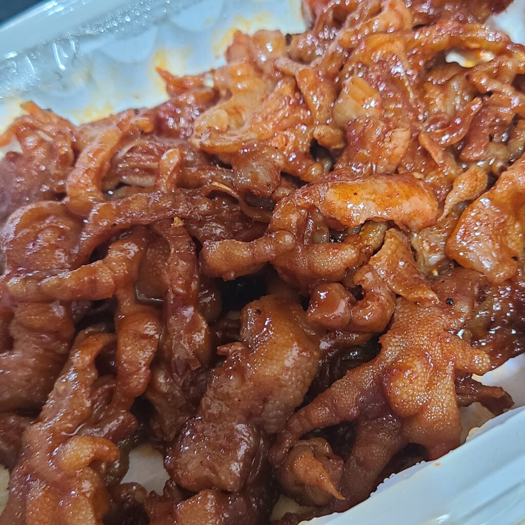 A plate of spicy stir-fried chicken feet showing the glossy red chili glaze (Photo: Youngsil, CC BY-SA 4.0 via Wikimedia Commons)