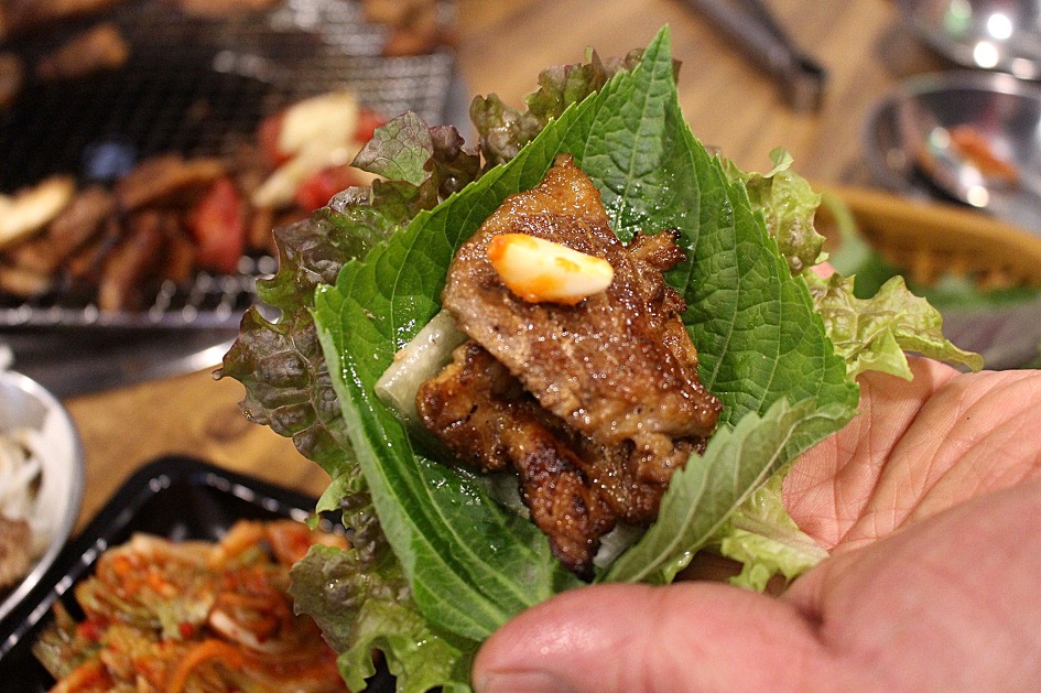 Grilled pork rib wrapped as ssam in a lettuce leaf with ssamjang. (Photo: 대경라이프 (Daekyung Life), CC BY-SA 4.0 via Wikimedia Commons)