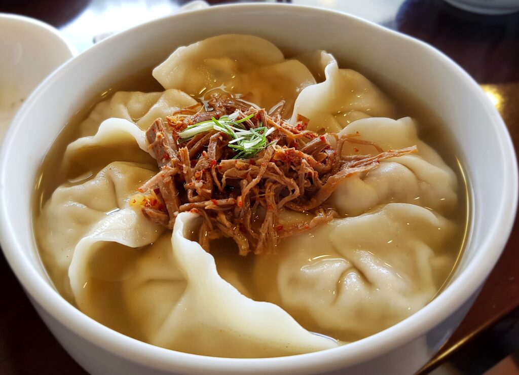 손만두/만두국 (mandu-guk / Korean dumpling soup) — a representative photo of the dish, not necessarily from the restaurants above. Photo: Trainholic (Wikimedia Commons user), CC BY-SA 4.0