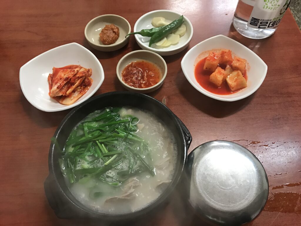 돼지국밥 (Dwaeji-gukbap / pork-soup rice) — a representative photo of the dish, not necessarily from the restaurants above. Photo: Photo by chomjong (Flickr: flickr.com/photos/112024099@N03/), via Wikimedia Commons, licensed CC BY 2.0 (https://creativecommons.org/licenses/by/2.0)