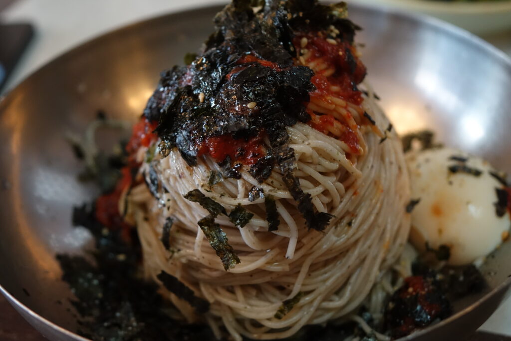 막국수 (Makguksu / cold buckwheat noodles) — a representative photo of the dish, not necessarily from the restaurants above. Photo: Photo by 최광모 (Choi Kwang-mo) via Wikimedia Commons, CC0 1.0