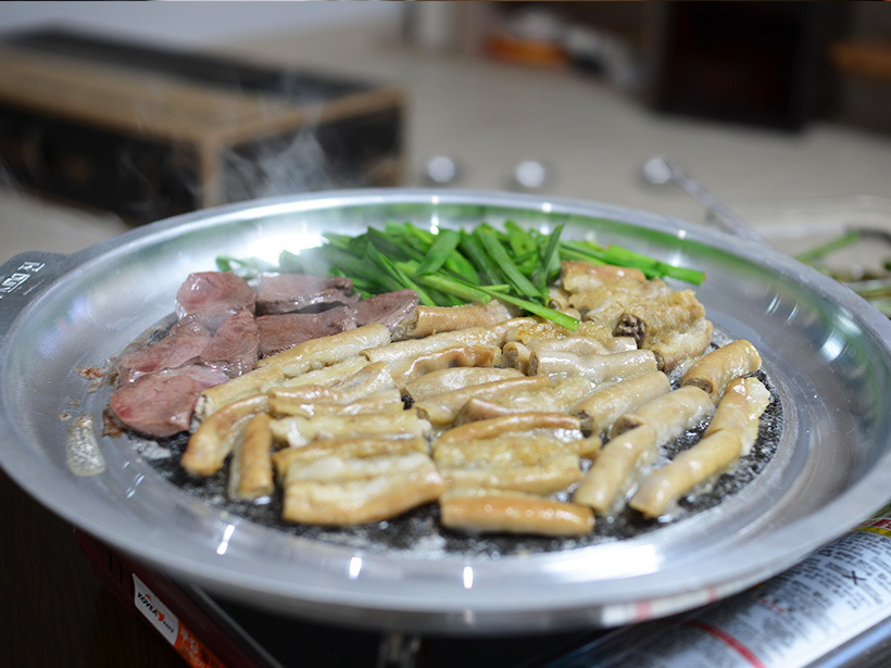 Gopchang grilling on a hot plate, here served alongside yeomtong (beef heart).