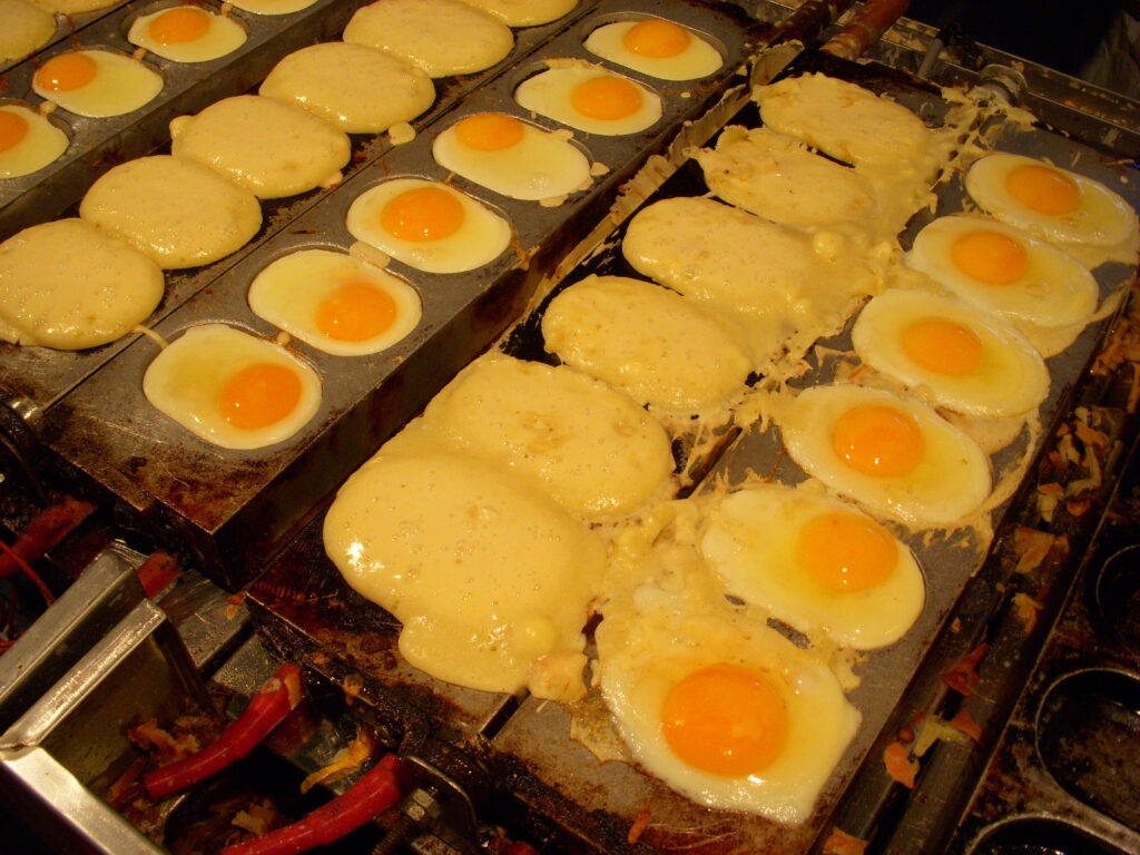 Close-up of gyeranppang: gently sweet bread with a plain or lightly salted egg baked into the top.