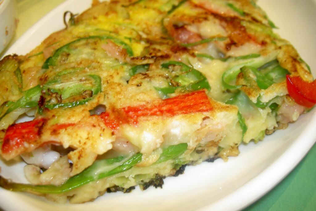 A finished haemul-pajeon, ready to cut into squares and share with a soy-vinegar dipping sauce.