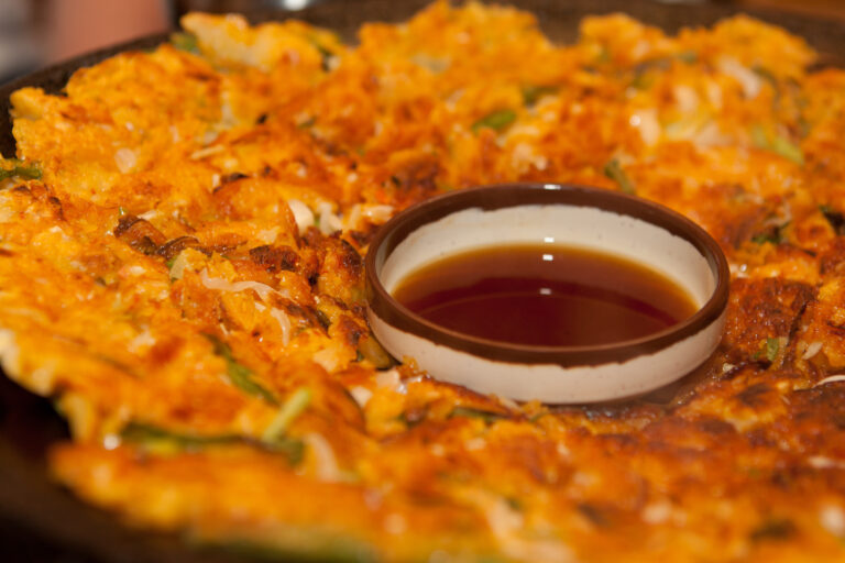 Haemul-pajeon, the Korean seafood and scallion pancake, served whole on a plate.