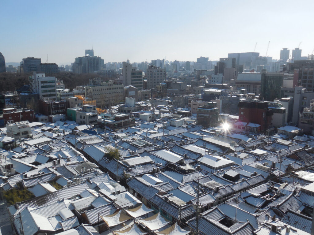 An elevated view across Ikseon-dong's dense hanok rooftops in Jongno-gu — central Seoul's highest hanok density. (Photo: Omogun (User:오모군) via Wikimedia Commons, CC BY 3.0)