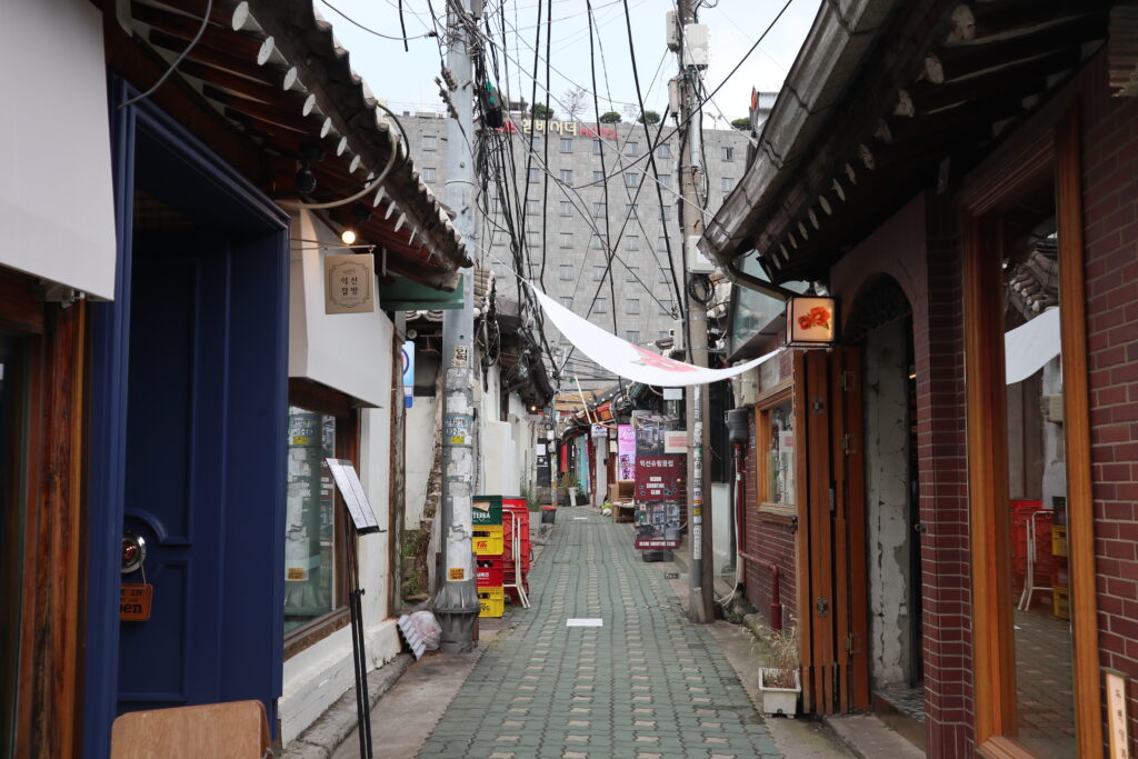 A narrow flagstone alley in Ikseon-dong, lined wall-to-wall with traditional hanok houses turned cafes and shops. (Photo: S h y numis via Wikimedia Commons, CC BY-SA 4.0)