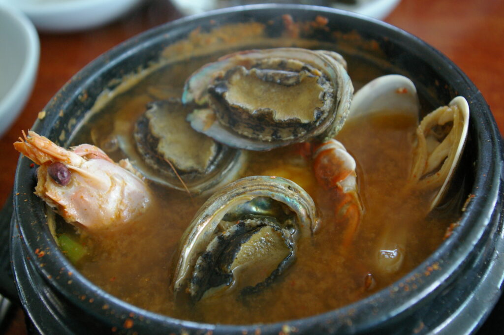 Bomal/obunjagi ttukbaegi, a Jeju top-shell stew served in an earthenware pot. Photo: 아침꿀물 / Wikimedia Commons (CC BY-SA 3.0).