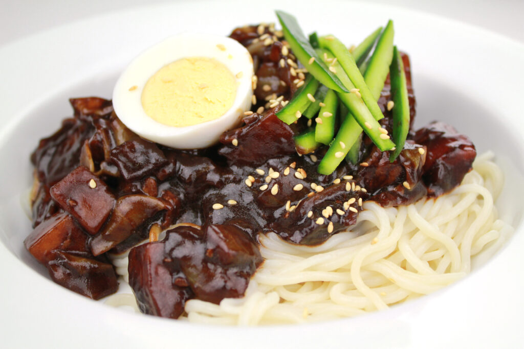 Toss the black sauce through the noodles until every strand is coated, then eat fast while it's hot. Photo: KFoodaddict / Wikimedia Commons / CC BY 2.0.