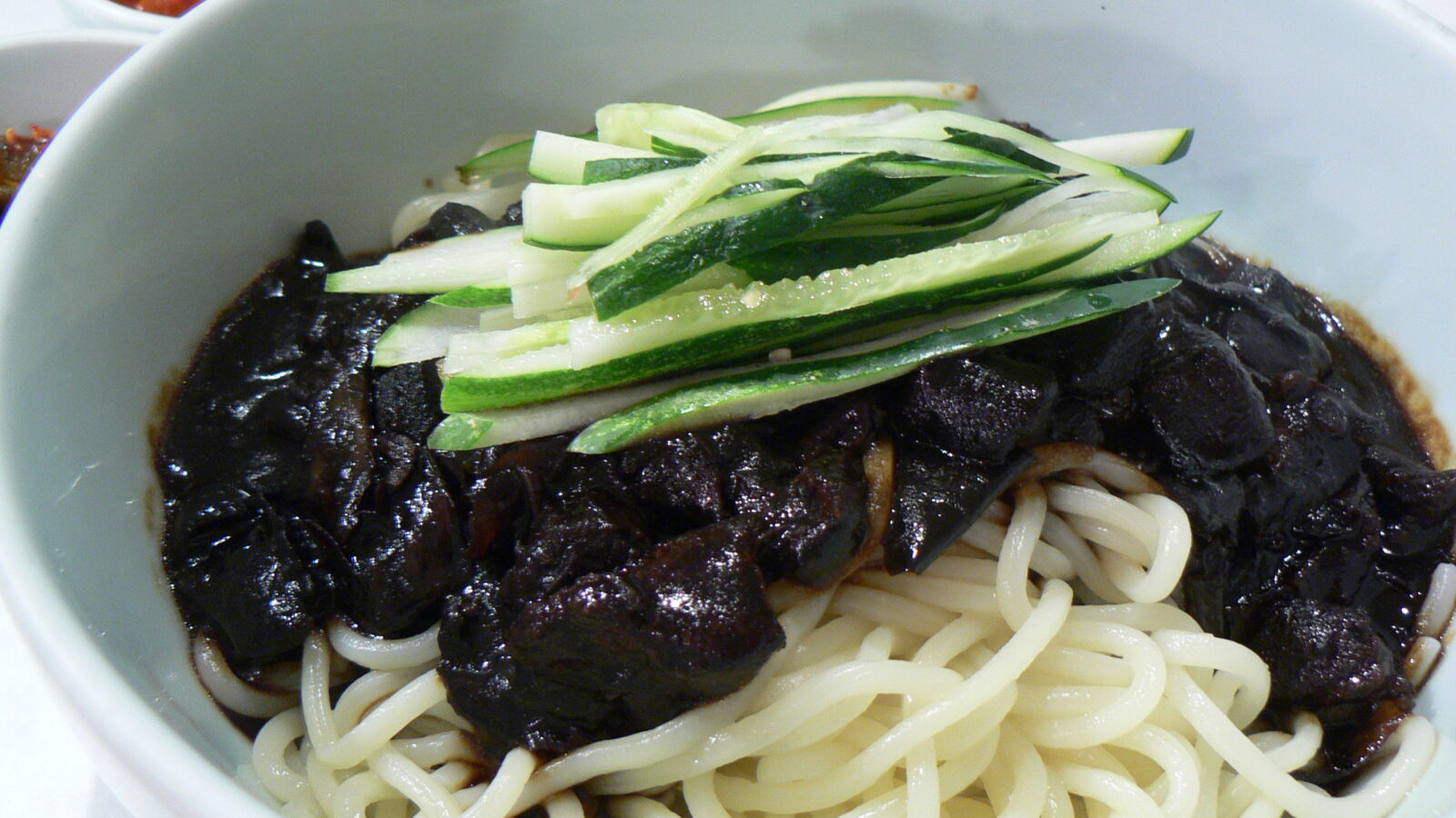 Jjajangmyeon: chewy wheat noodles under a glossy black-bean sauce, served in a single bowl. Photo: stu_spivack / Wikimedia Commons / CC BY-SA 2.0.