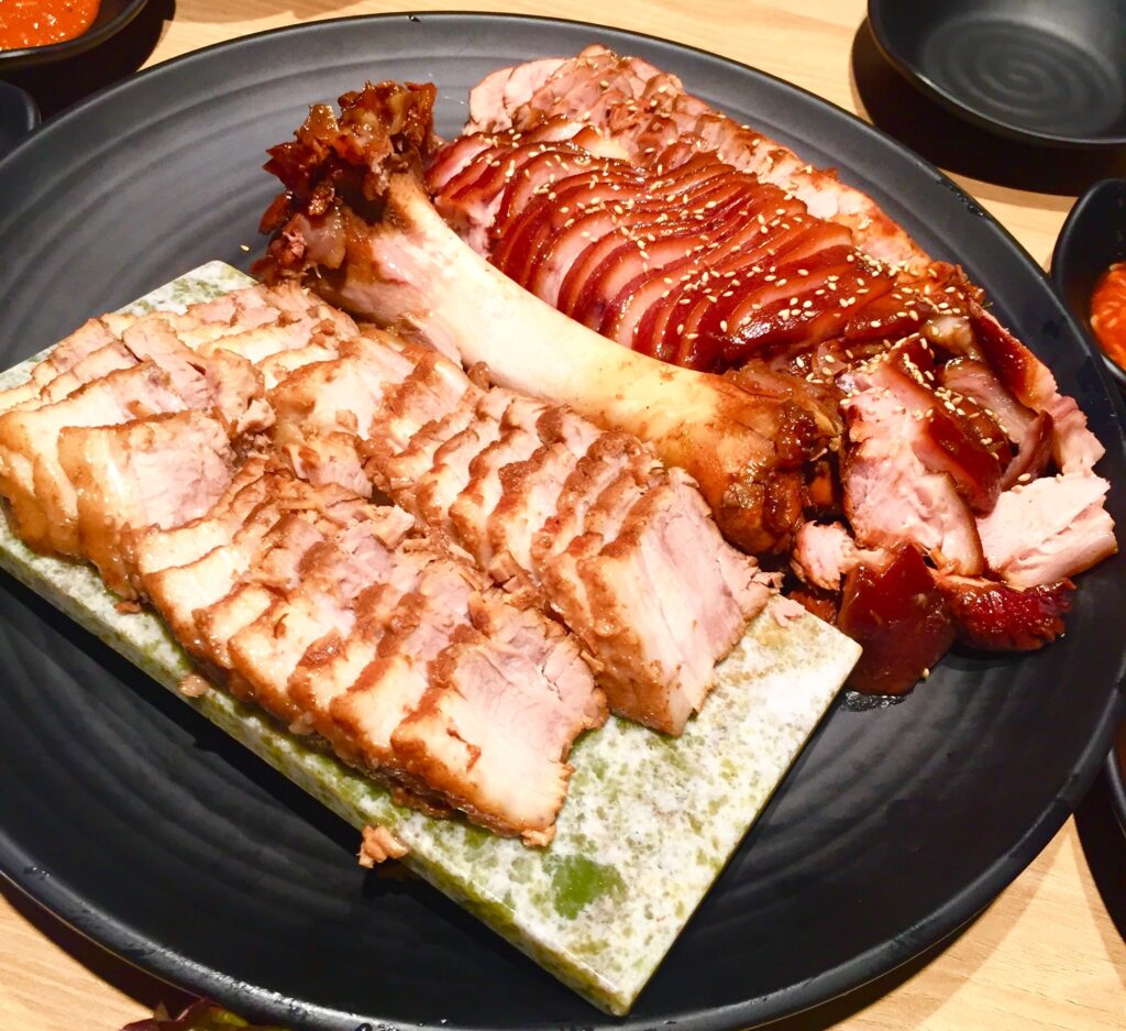 Jokbal served alongside bossam, its boiled-pork cousin — both eaten ssam-style. (Photo: Jungyeon Min, CC0 via Wikimedia Commons)