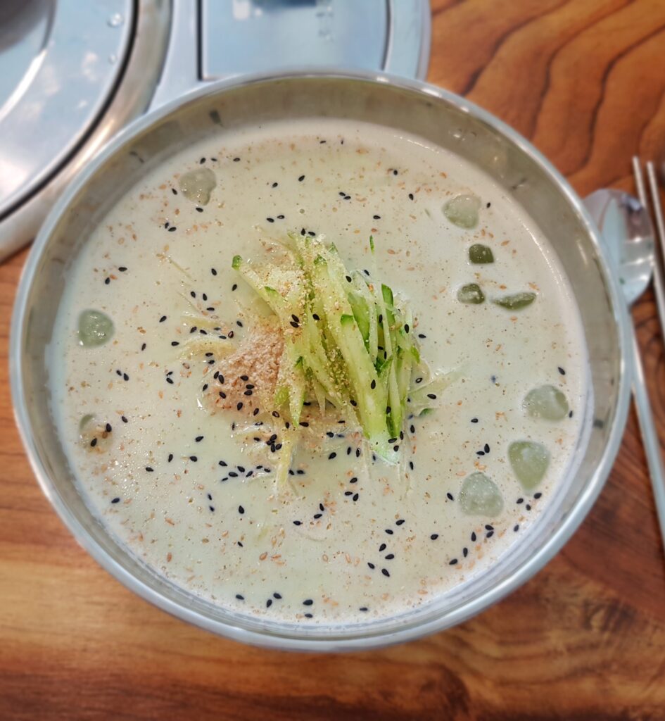Seoritae kongguksu (서리태 콩국수), made with black soybeans, which give the broth a pale gray-purple color and earthier flavor. (Photo: Hyerimwon, CC BY-SA 4.0 via Wikimedia Commons)