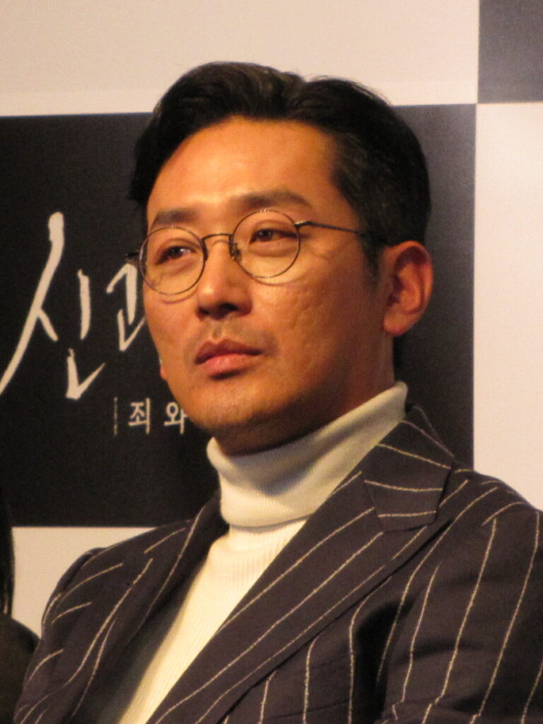 Ha Jung-woo (하정우), who plays civilian-turned-informant Kang In-gu, at a film event. This is a press photo, not a still from Narco-Saints. (Photo: sisaprime, CC BY 4.0 via Wikimedia Commons)