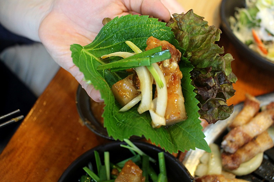 A samgyeopsal ssam: grilled pork belly wrapped with garnish and ssamjang, built to eat in one bite. (Photo: 대경라이프 / Daegyeong Life, Wikimedia Commons, CC BY-SA 4.0)