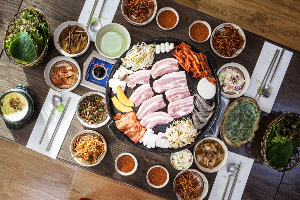 A samgyeopsal table set with the meat and its spread of banchan. (Photo: 이동원 / Lee Dong-won via Pixabay, CC0 / public domain)