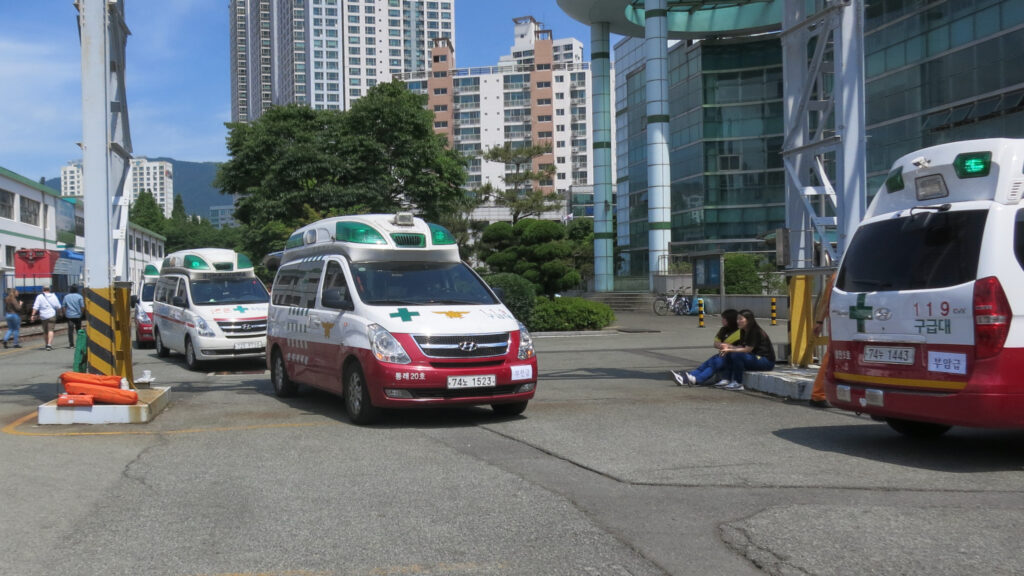 South Korean emergency-medical ambulances lined up at an emergency-response drill. Illustrative of Korea's emergency/trauma medical services depicted in 'The Trauma Code: Heroes on Call'; not the show's actual filming location. (Photo: Matsujima, CC BY-SA 4.0 via Wikimedia Commons)