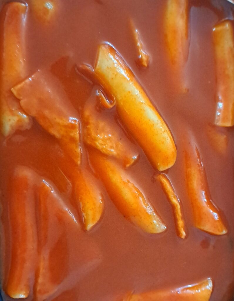 Tteokbokki served as 분식 street food — the everyday comfort dish Korean teenagers grow up on.