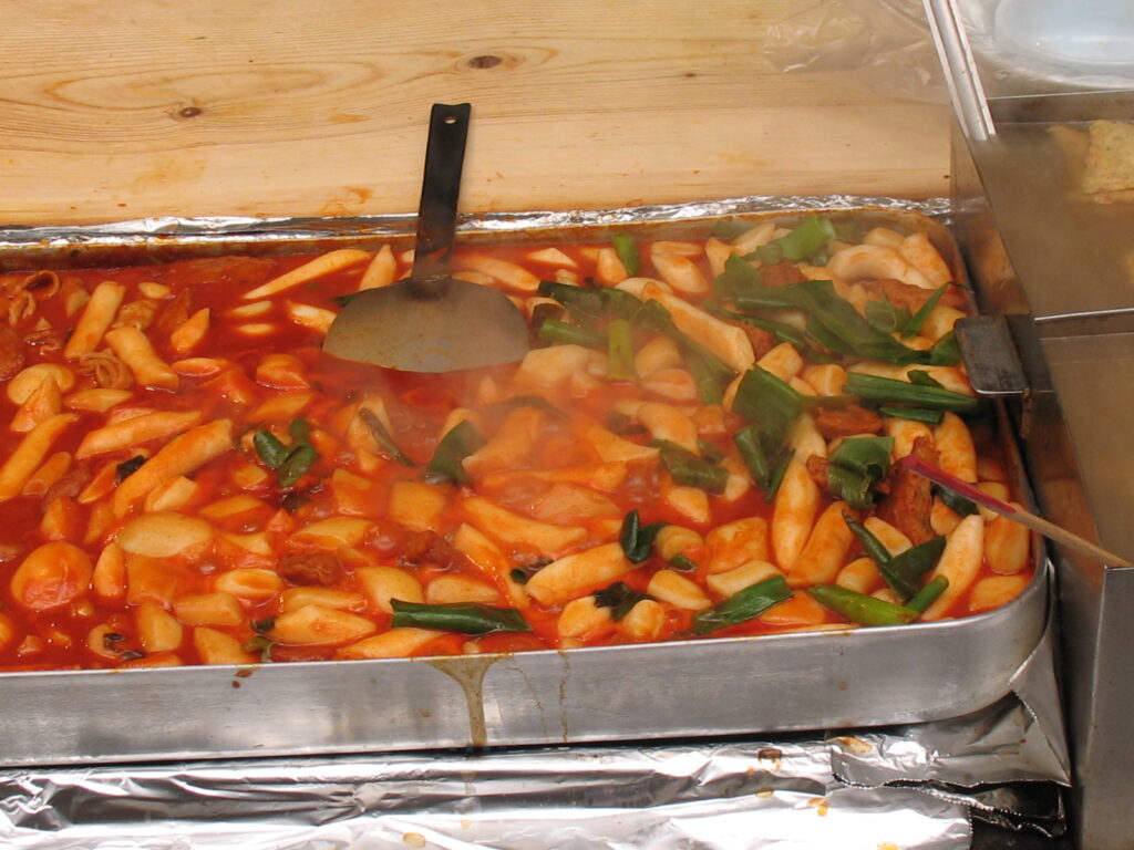 Tteokbokki with 어묵 fish cake in a thick, shiny sauce, finished snack-bar style.