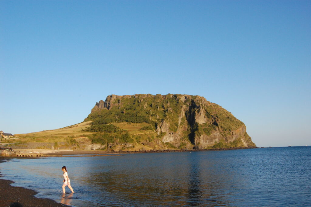 Seongsan Ilchulbong, the tuff cone in Seongsan-eup, Jeju, near the area that inspired the fictional village (a regional landmark, not a confirmed shooting site). (Photo: Justin De La Ornellas, CC BY 2.0, via Wikimedia Commons)