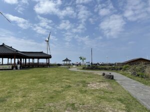 The Sinchang Windmill Coastal Road on Jeju Island, a confirmed Welcome to Samdal-ri filming location. (Photo: Grapesurgeon, CC BY-SA 4.0, via Wikimedia Commons)
