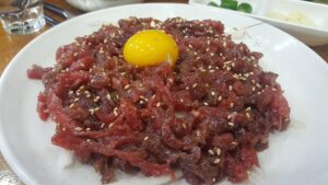 Yukhoe served at Gwangjang Market, Seoul, topped with egg yolk and julienned Korean pear (Photo: Choi2451, CC BY-SA 3.0 via Wikimedia Commons)